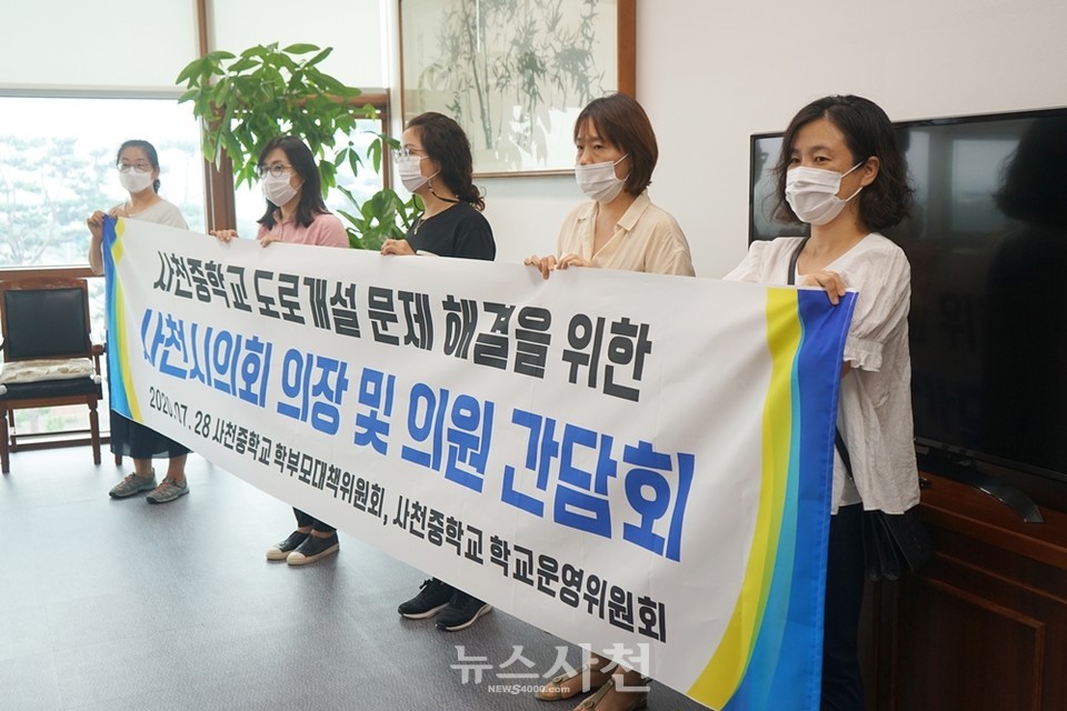 간담회에 참석한 사천중학교 학부모대책위원회가 현수막을 들고 있다.