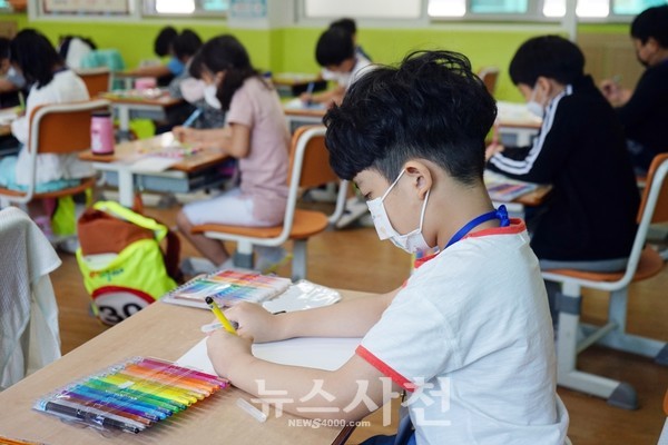 지난 5월 사천 삼성초등학교 1학년 학생들이 마스크를 끼고 수업을 듣고 있다.