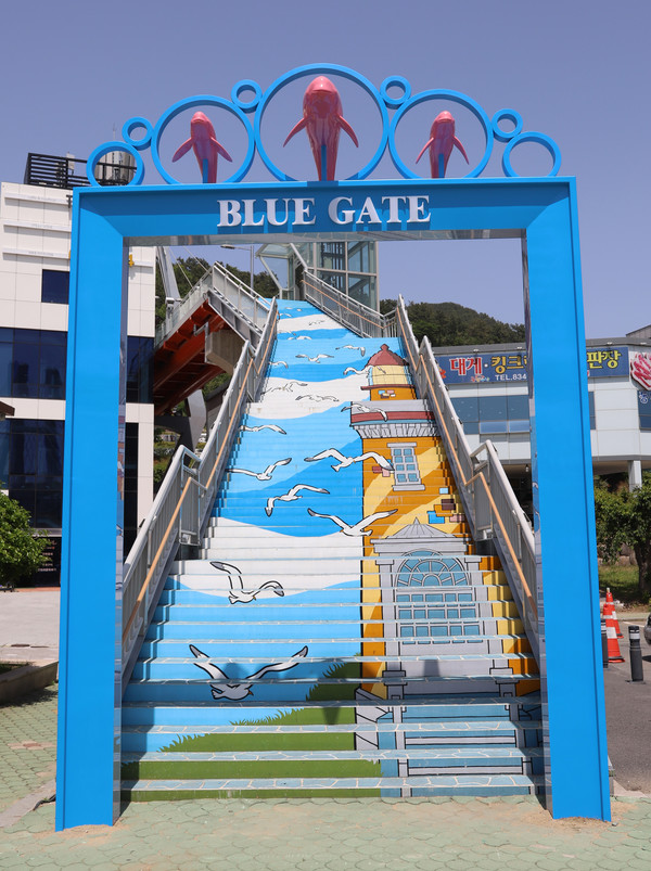 삼천포대교공원과 사천바다케이블카를 연결하는 다리인 ‘다이아몬드브릿지’ 입구에 설치된 파란색 문 형태의 ‘블루게이트’ 조형물.