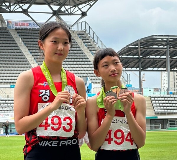 이번 대회 육상경기 3관왕을 기록한 박민주 선수(오른쪽)와 세단뛰기에서 은메달을 딴 구나영 선수가 메달을 들어 보이고 있다.(사진=사천시체육회)